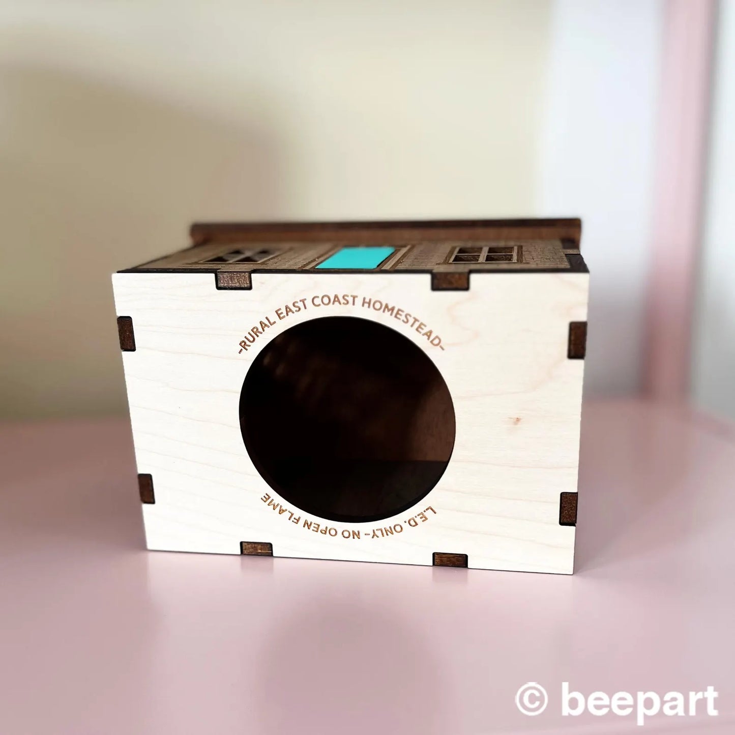 Wooden p house with circular entrance on a pink surface, branded 'beepar